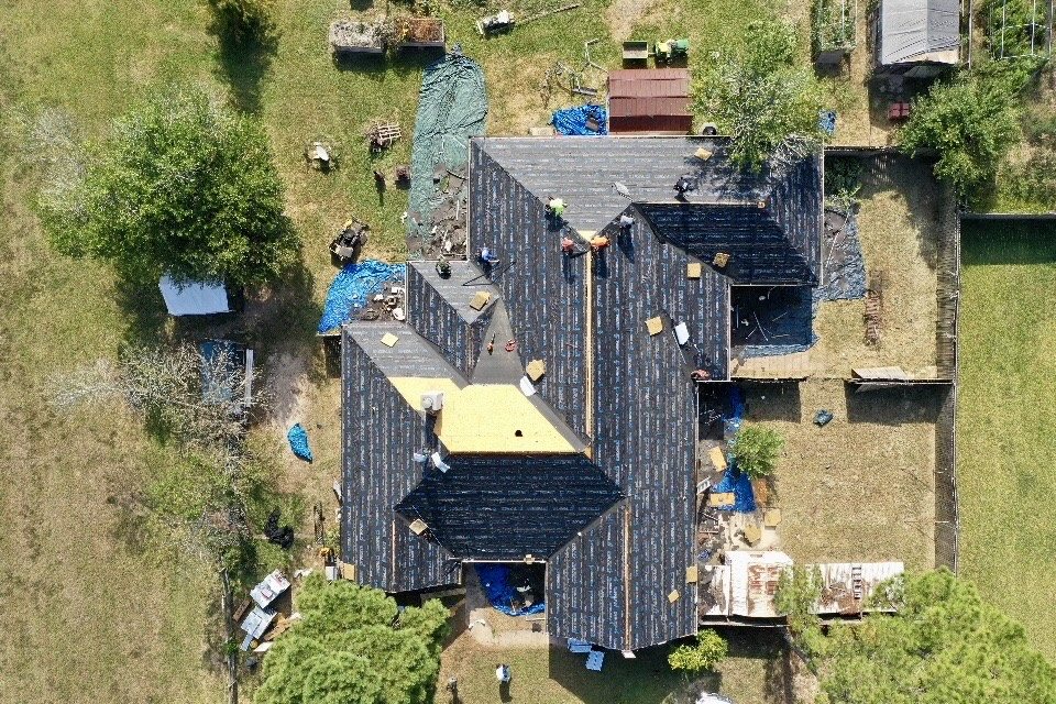 Trophy Exteriors roofer installing shingles